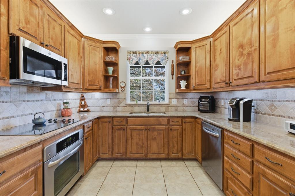 240 Johnson Bend Road Weatherford, TX 76088 - Photo 16 of 40 a kitchen with stainless steel appliances granite countertop a sink and a stove