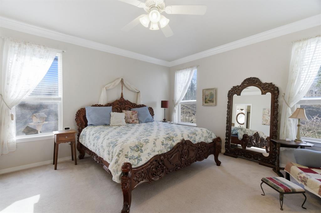 240 Johnson Bend Road Weatherford, TX 76088 - Photo 19 of 40 a bed room with a bed and a chandelier