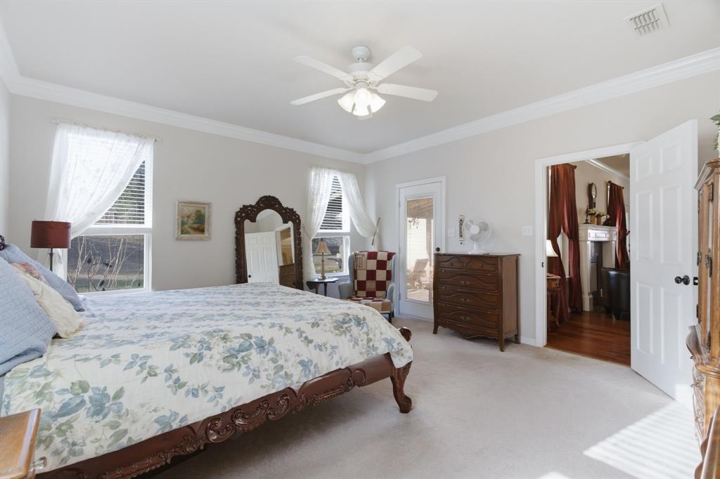 240 Johnson Bend Road Weatherford, TX 76088 - Photo 20 of 40 a bedroom with a large bed and a chandelier