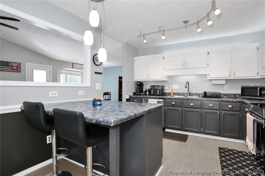 304 Kernstown Road Raeford, NC 28376 - Photo 11 of 33 a kitchen with a dining table chairs cabinets and stainless steel appliances