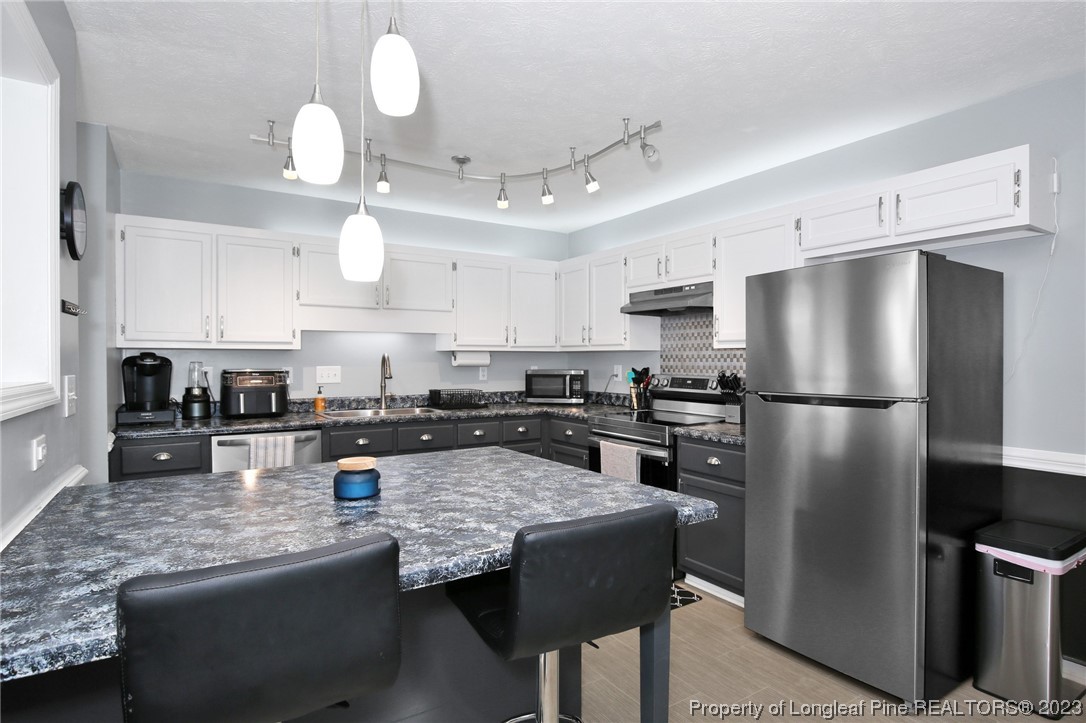 304 Kernstown Road Raeford, NC 28376 - Photo 12 of 33 a kitchen with granite countertop a refrigerator a stove a sink a center island and cabinets