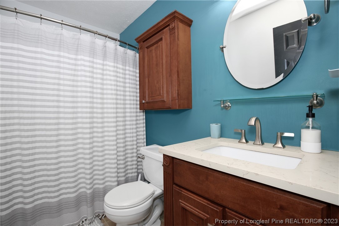 304 Kernstown Road Raeford, NC 28376 - Photo 25 of 33 a bathroom with a sink a toilet and mirror