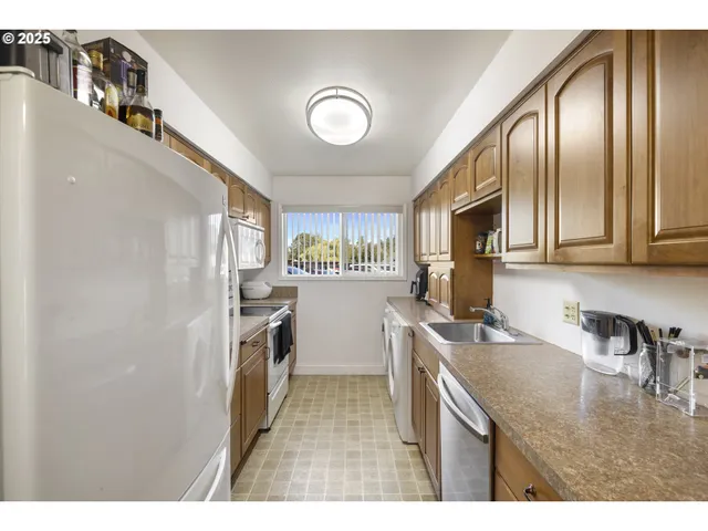 a kitchen with stainless steel appliances granite countertop a sink a stove cabinets and a refrigerator