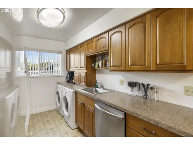 a kitchen with kitchen island granite countertop a sink a counter space and cabinets
