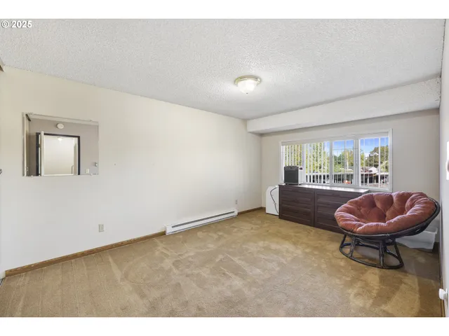 a view of an empty room with a ceiling fan and carpet