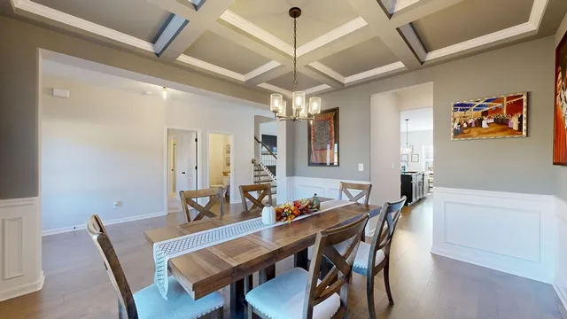 a kitchen with stainless steel appliances granite countertop a table chairs and a refrigerator