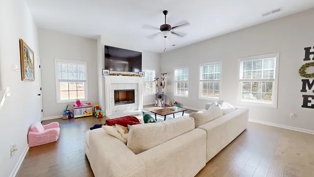 a living room with furniture a flat screen tv and a fireplace