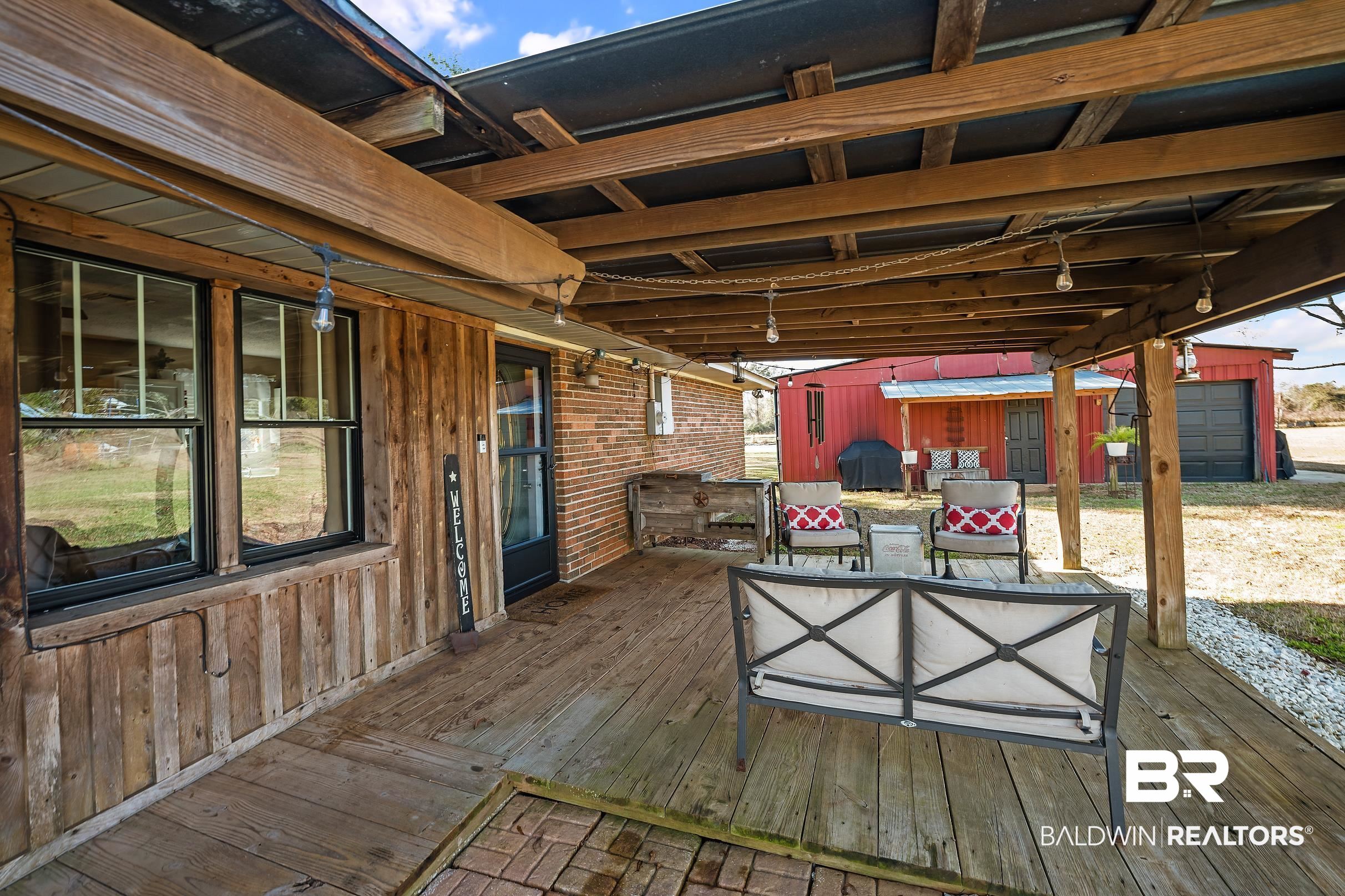 110 Sam Jones Road Atmore, AL 36502 - Photo 10 of 47 Wooden terrace with an outbuilding, area for grilling, and an outdoor living space