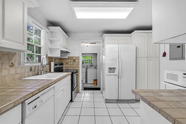 a kitchen with stainless steel appliances a refrigerator sink and cabinets