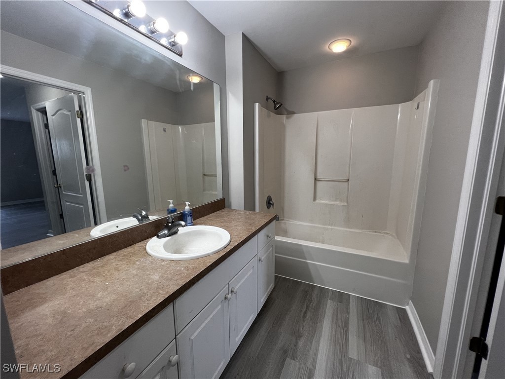672 Homestead Road South Lehigh Acres, FL 33974 - Photo 20 of 35 a bathroom with a granite countertop sink a mirror a bathtub and shower