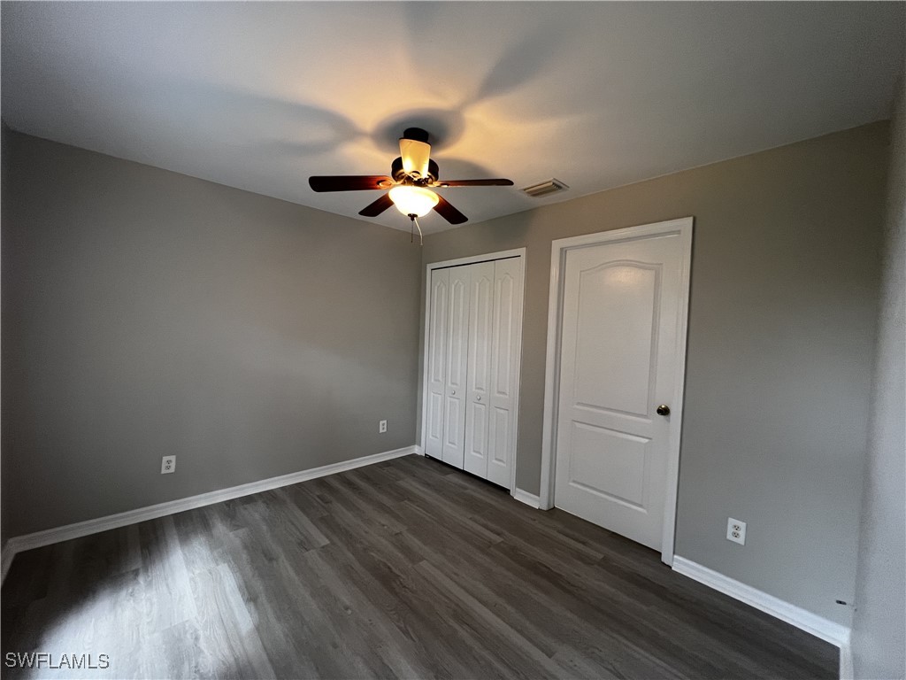 672 Homestead Road South Lehigh Acres, FL 33974 - Photo 21 of 35 wooden floor in an empty room with a window