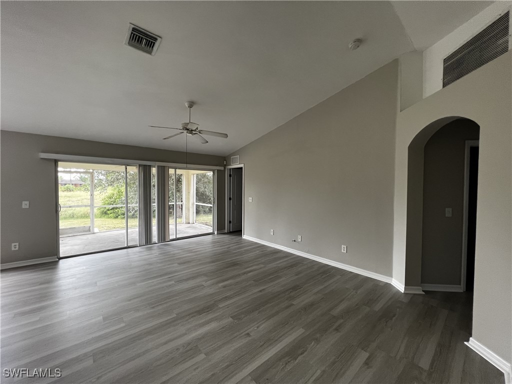 672 Homestead Road South Lehigh Acres, FL 33974 - Photo 3 of 35 a view of an empty room with wooden floor and a window