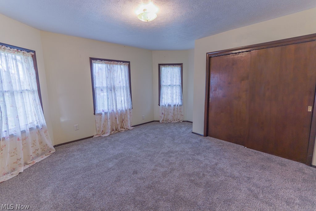 51883 Telegraph Road Amherst, OH 44001 - Photo 15 of 49 Unfurnished bedroom with a closet, a textured ceiling, and carpet floors