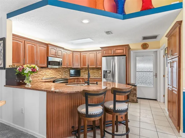 a kitchen with stainless steel appliances granite countertop a refrigerator sink and cabinets