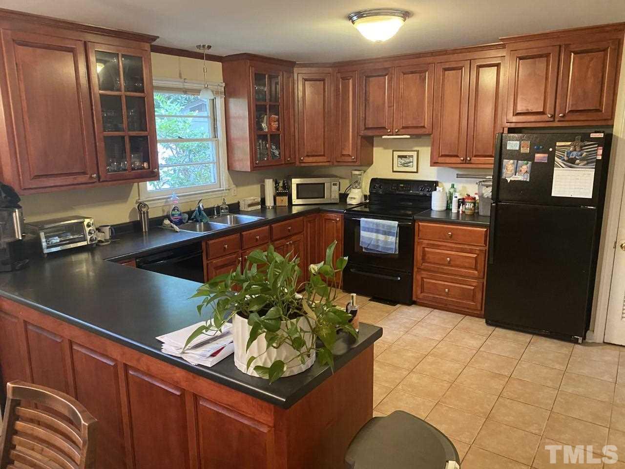 1412 Lyon Street Raleigh, NC 27608 - Photo 4 of 6 a kitchen with granite countertop stainless steel appliances a stove a sink a refrigerator and cabinets