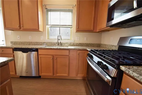 a kitchen with granite countertop a sink stove and cabinets