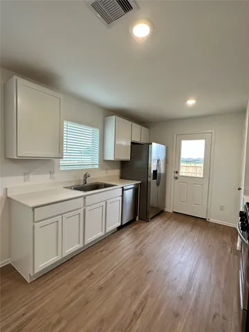 a kitchen with stainless steel appliances granite countertop a stove a sink and a refrigerator