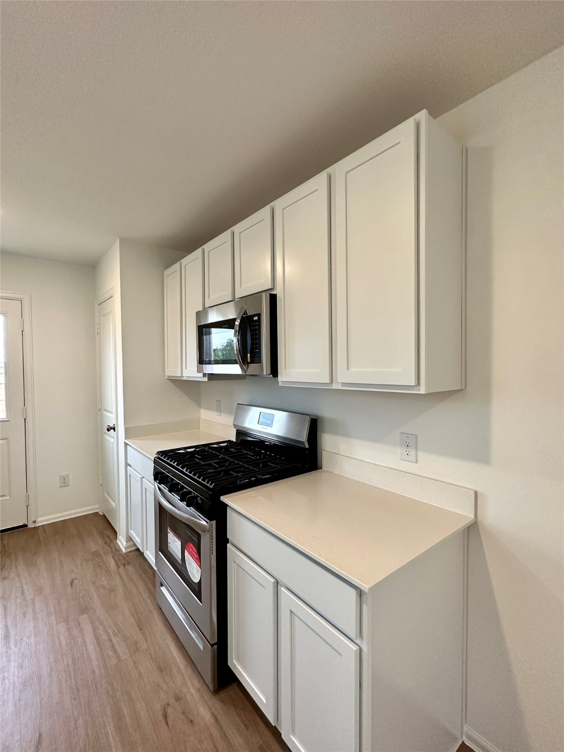 4130 Brazos Brook Trail Baytown, TX 77521 - Photo 7 of 20 a kitchen with stainless steel appliances a stove a microwave a sink and cabinets