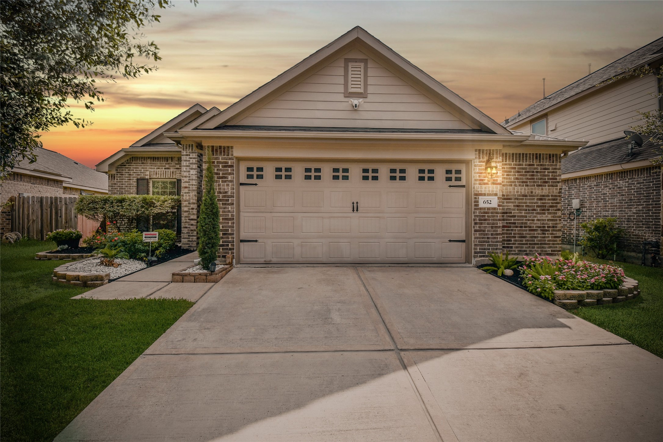 652 Maple Point Drive East Conroe, TX 77301 - Photo 3 of 35 Charming single-story brick home with a two-car garage, well-maintained front yard, and attractive landscaping. The warm lighting and sunset backdrop offer a welcoming feel.