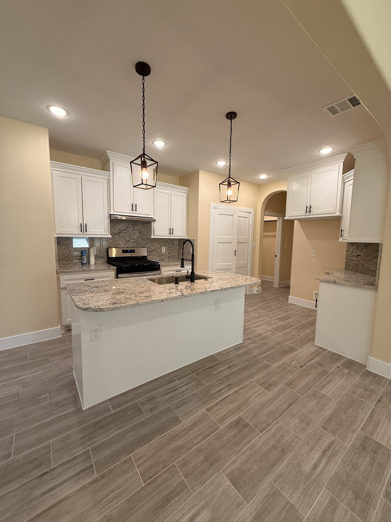 14844 Coaltown Road Willis, TX 77378 - Photo 15 of 30 a large kitchen with kitchen island a stove a sink a refrigerator and white cabinets