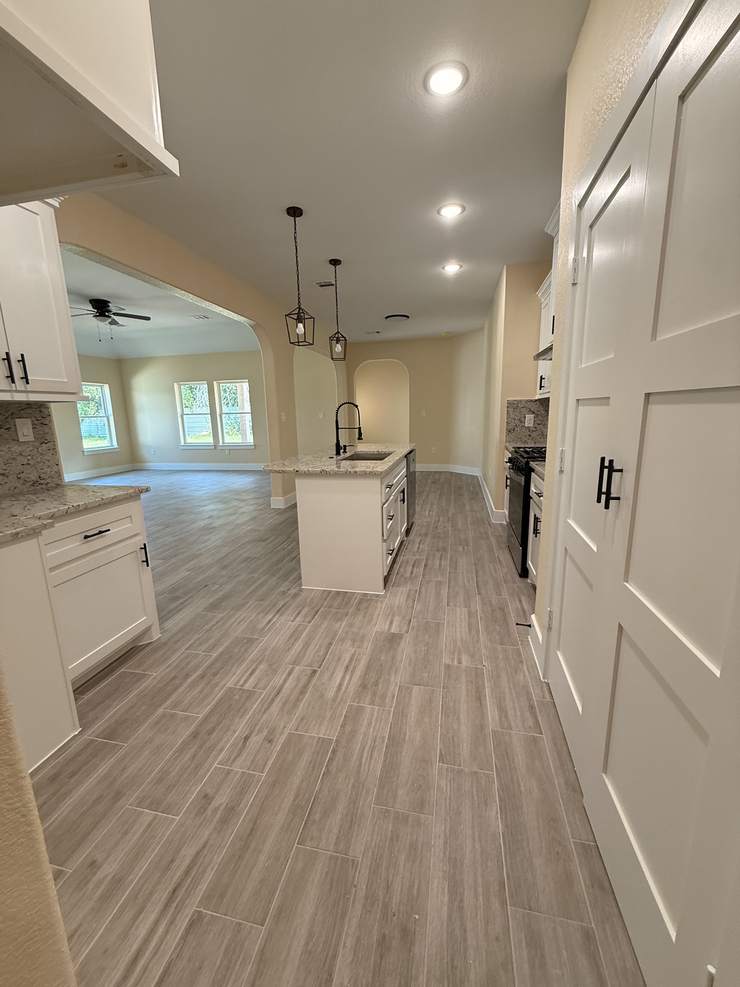 14844 Coaltown Road Willis, TX 77378 - Photo 19 of 30 a open kitchen with white cabinets and wooden floor