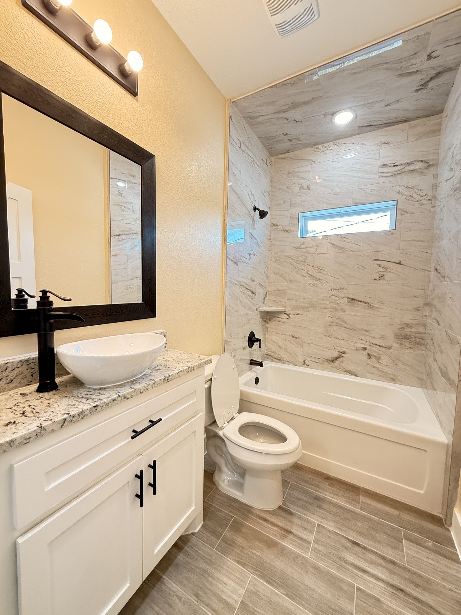 14844 Coaltown Road Willis, TX 77378 - Photo 26 of 30 a bathroom with a granite countertop toilet a sink and a bathtub