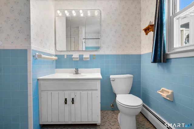 a bathroom with a toilet a sink and mirror