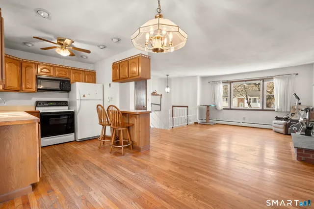 a view of a dining room with furniture a chandelier and wooden floor