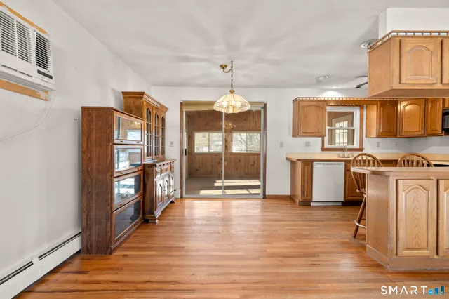 a view of a kitchen with refrigerator and wooden floor