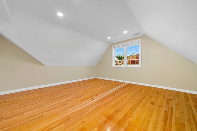 a spacious bedroom with a large bed and a flat tv screen