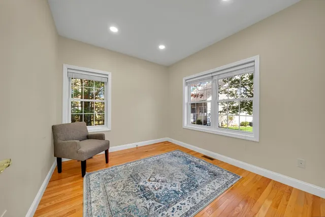 a kitchen with stainless steel appliances granite countertop a stove top oven a sink dishwasher and white cabinets with wooden floor