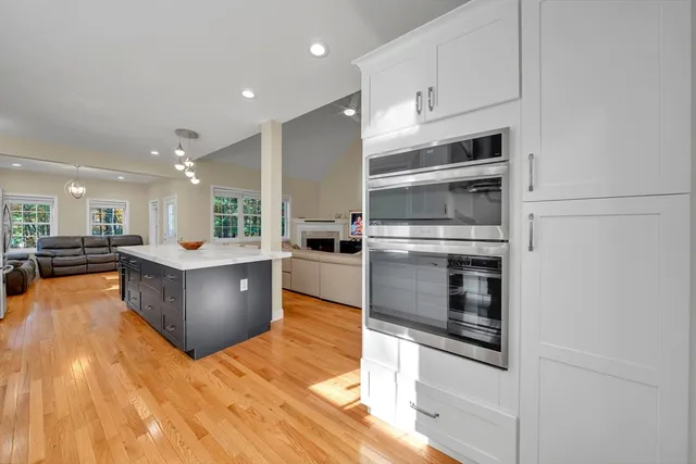 a large kitchen with stainless steel appliances kitchen island granite countertop a stove and a sink