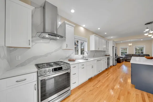 a kitchen with kitchen island a refrigerator stove and wooden floor