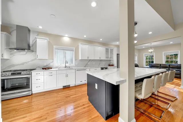 a kitchen with granite countertop white cabinets and wooden floor
