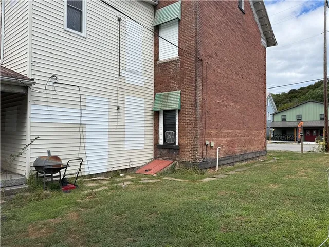 a backyard of a house with table and chairs