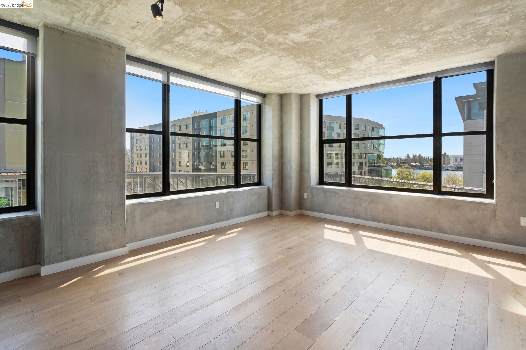 311 2nd Street, Unit 511 Oakland, CA 94607 - Photo 13 of 44 Unfurnished room with light wood finished floors, a city view, and plenty of natural light