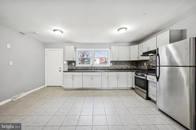 a kitchen with stainless steel appliances a refrigerator sink and cabinets