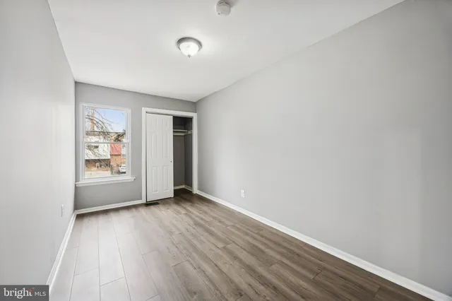 a view of an empty room with closet and a window