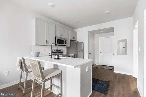 a kitchen with kitchen island a stove a table and chairs