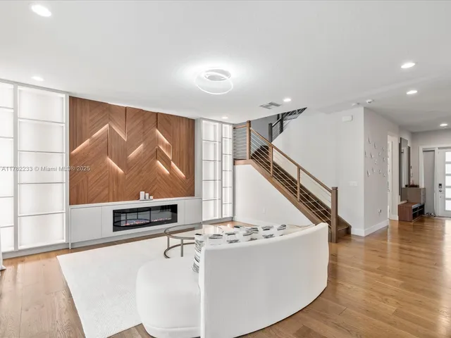 a living room with furniture a flat screen tv and a large window