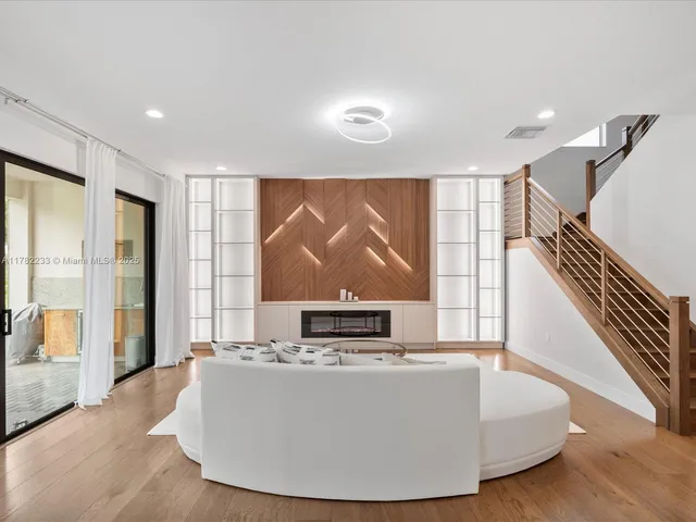 a living room with furniture a large window and kitchen view