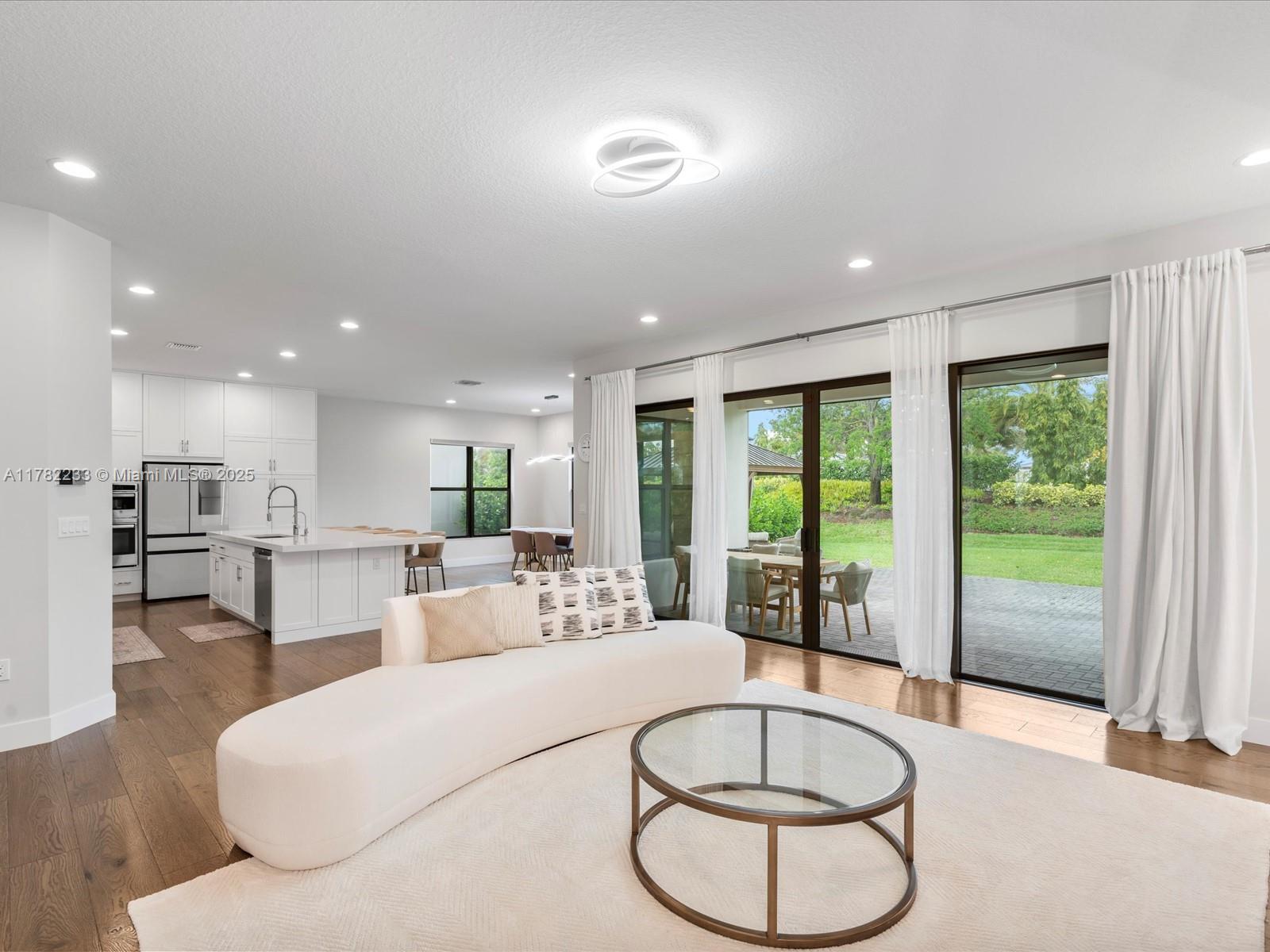 20324 Castle Stuart Avenue Boca Raton, FL 33434 - Photo 15 of 79 a living room with furniture a large window and kitchen view