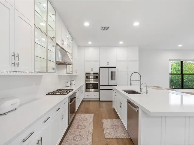 a large white kitchen with a large window