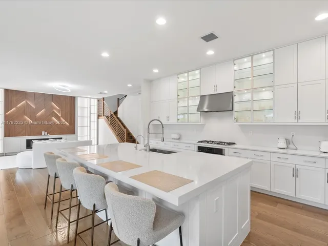 a kitchen with stainless steel appliances kitchen island granite countertop a kitchen island and chairs in it