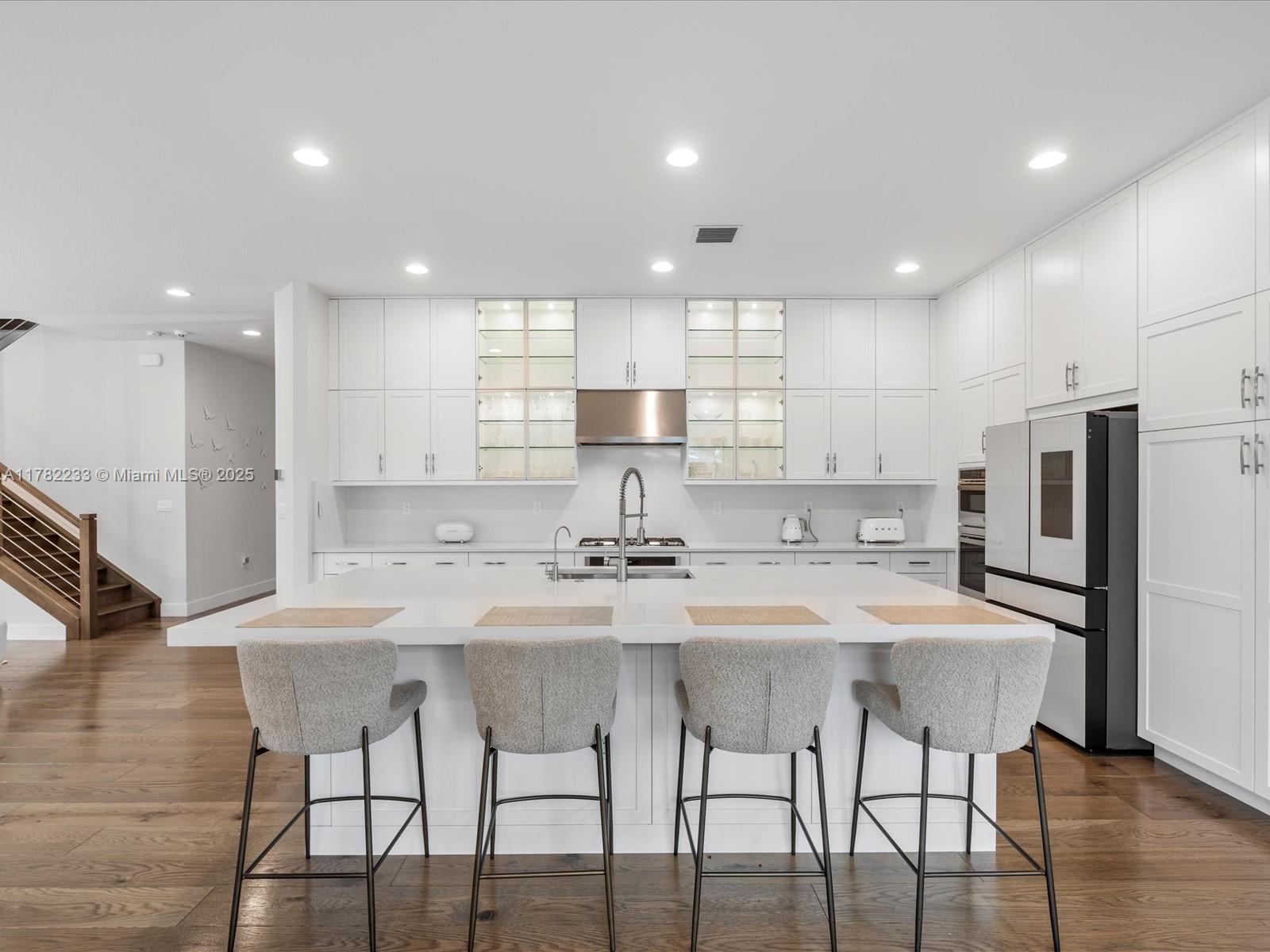 20324 Castle Stuart Avenue Boca Raton, FL 33434 - Photo 23 of 79 a kitchen with stainless steel appliances kitchen island granite countertop a kitchen island and chairs in it