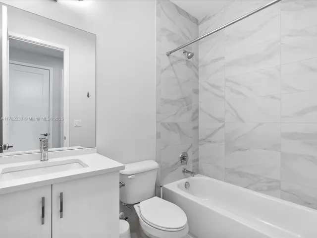a patio with a table and chairs and potted plants