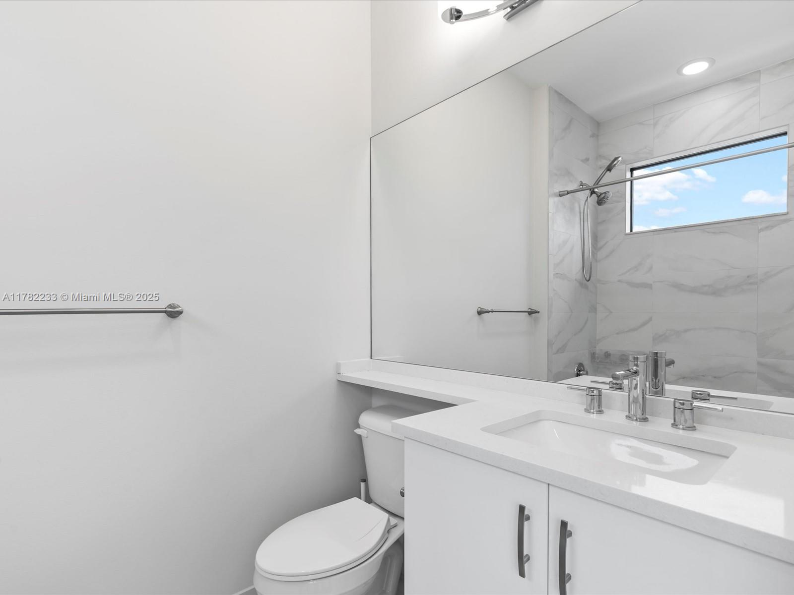 20324 Castle Stuart Avenue Boca Raton, FL 33434 - Photo 51 of 79 a bathroom with a sink a toilet and a mirror