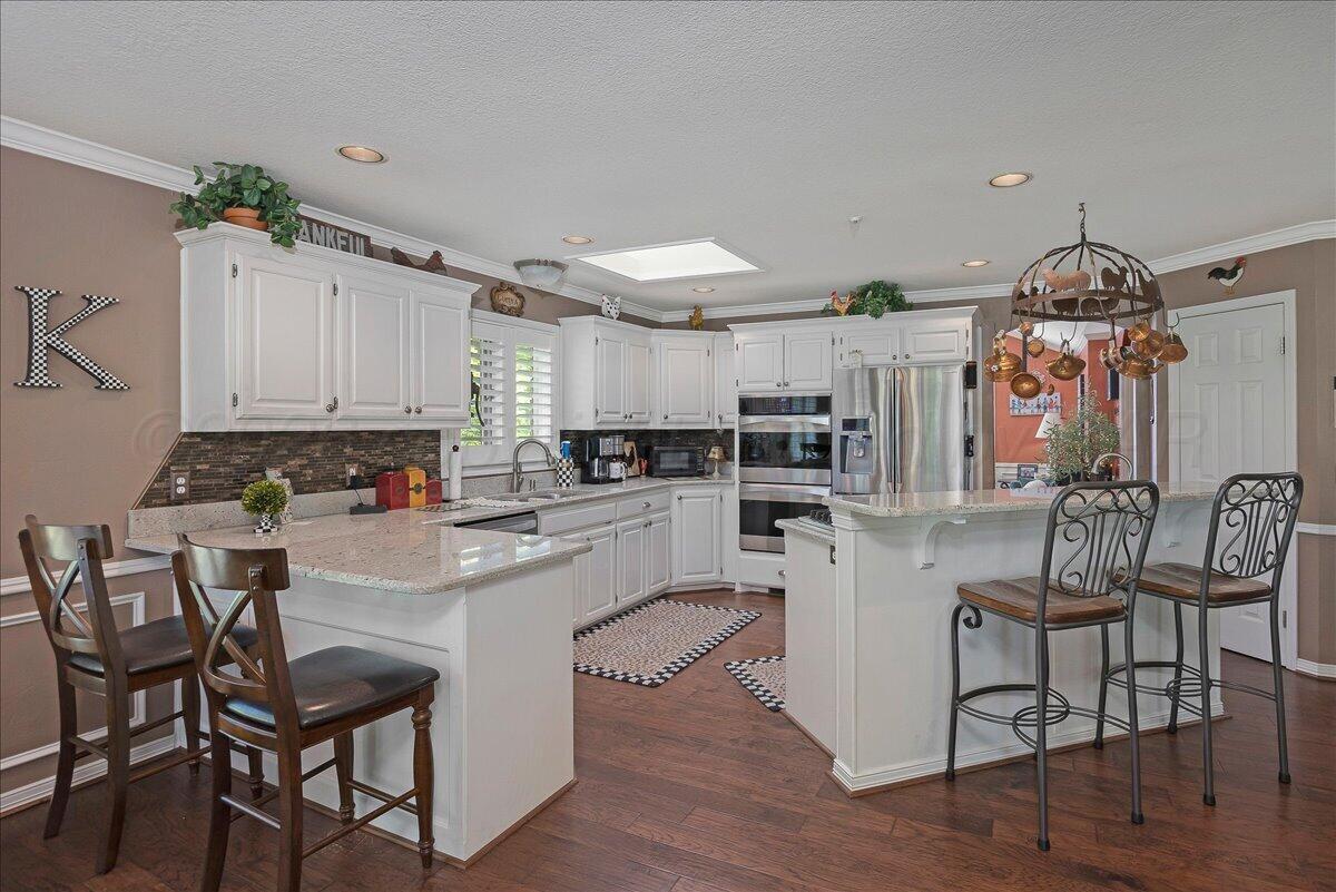 5 Locke Place Amarillo, TX 79124 - Photo 9 of 53 a kitchen with white cabinets and stainless steel appliances