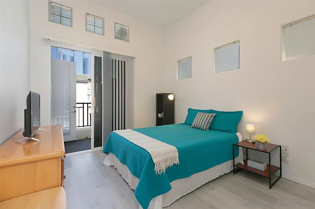 9237 Regents Road, Unit K401 La Jolla, CA 92037 - Photo 13 of 25 a bedroom with a bed wooden floor and a dresser