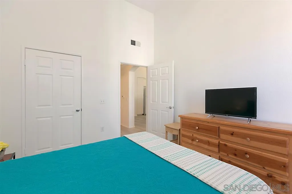 9237 Regents Road, Unit K401 La Jolla, CA 92037 - Photo 15 of 25 a bedroom with a bed and a flat screen tv